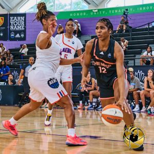 Female basketball player bouncing a basketball on the court.